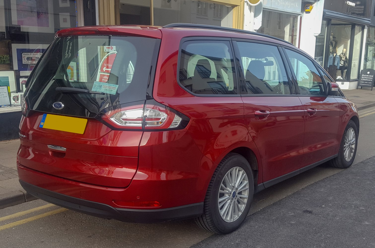 Rear side of red MPV with distinctive taillights and large windows