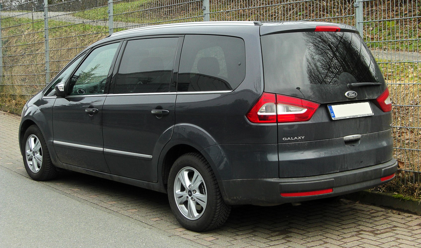 Rear-side view of a minivan with distinctive tail lights and tinted windows