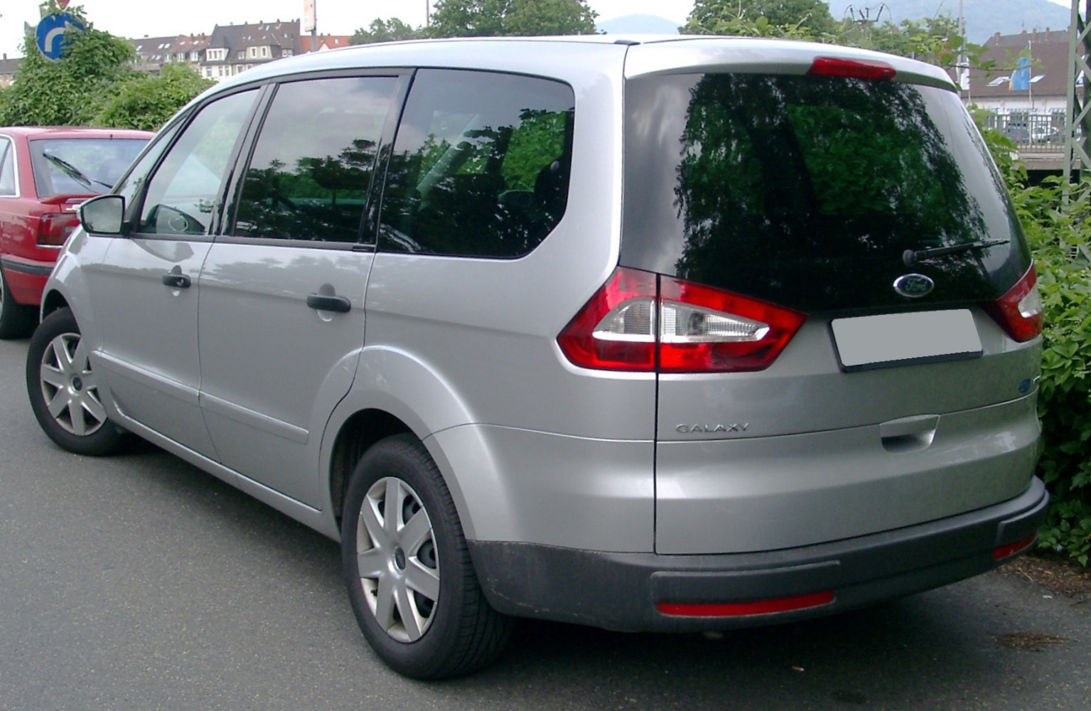 Silver MPV rear side with large rear window and distinctive taillights