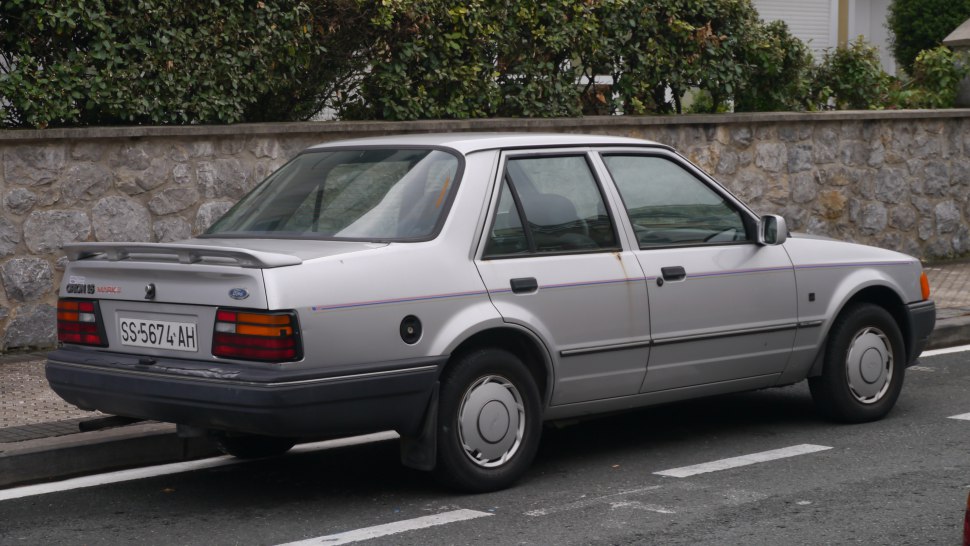 Silver 1980s sedan rear side with spoiler and classic taillights