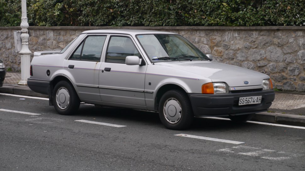 Silver four-door sedan with rear spoiler and hubcap wheels