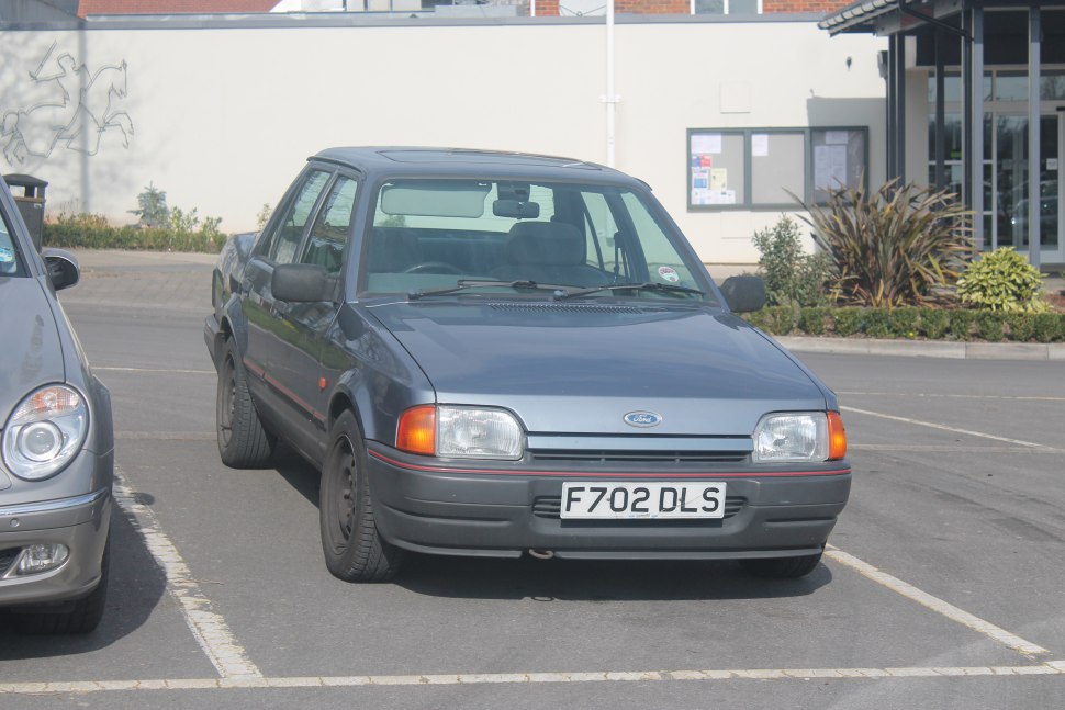 Front view of a 1980s sedan with rectangular headlights and black bumper.