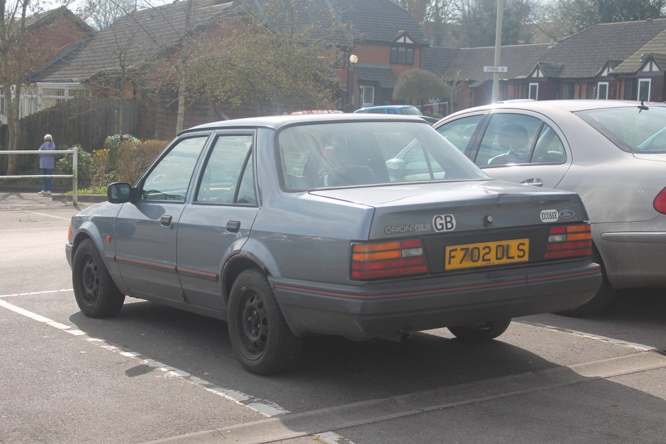 Rear-side view of a vintage four-door sedan with distinctive taillights and a boxy shape.