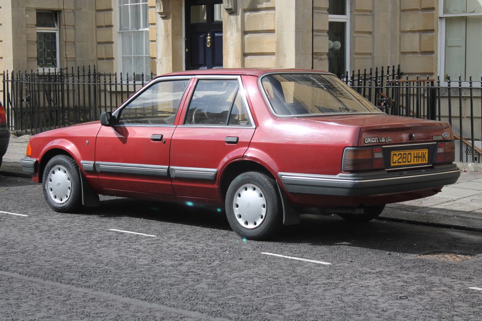 Four-door sedan rear side profile with rectangular taillights and steel wheels