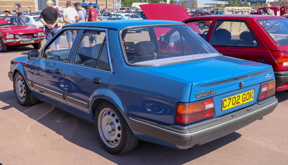 Rear angled view of a blue classic sedan with distinct 1980s design.