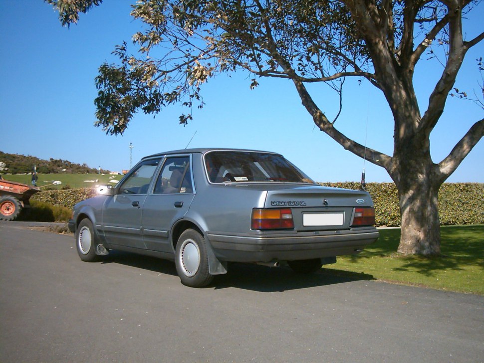 Rear side view of a classic 1980s sedan with distinct taillights and simple body lines.