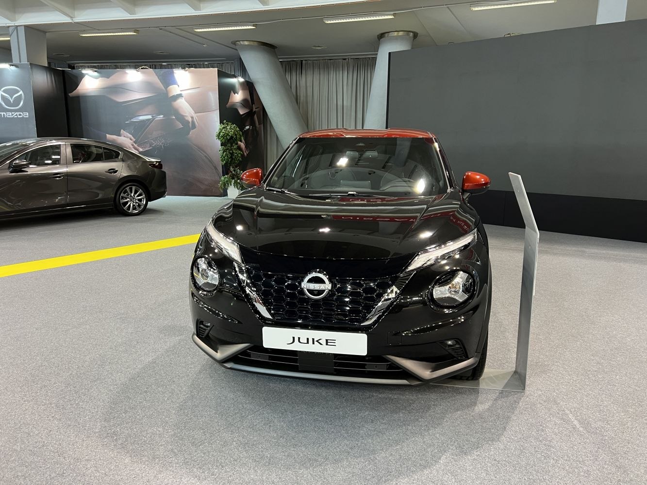 Front view of distinctive grille and headlights with two-tone black and orange body