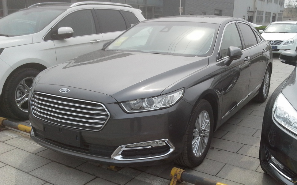 Front-side view of sedan with chrome grille and modern headlights