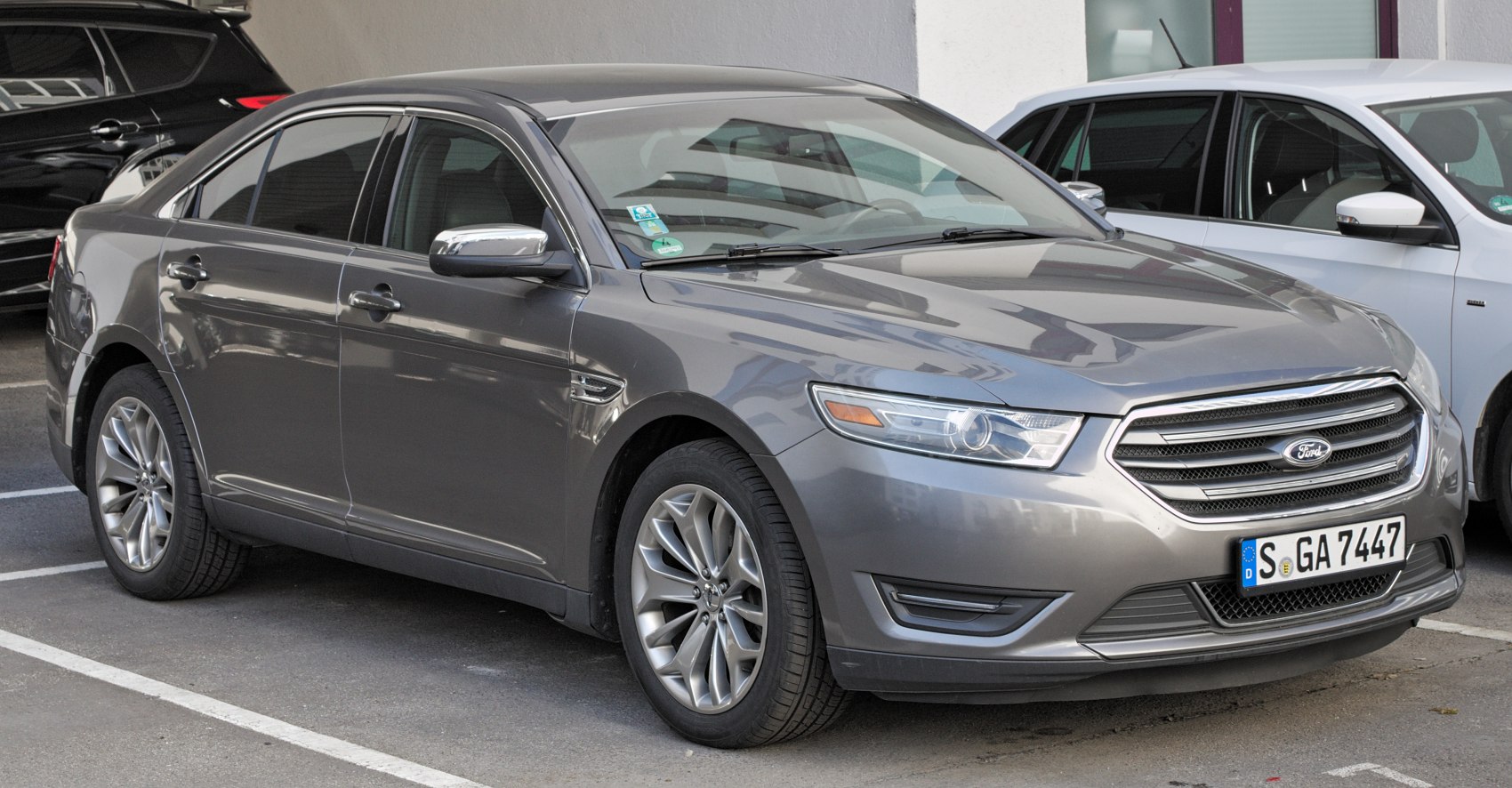 Front-side angle of a 2013 facelift sedan showcasing grille and alloy wheels