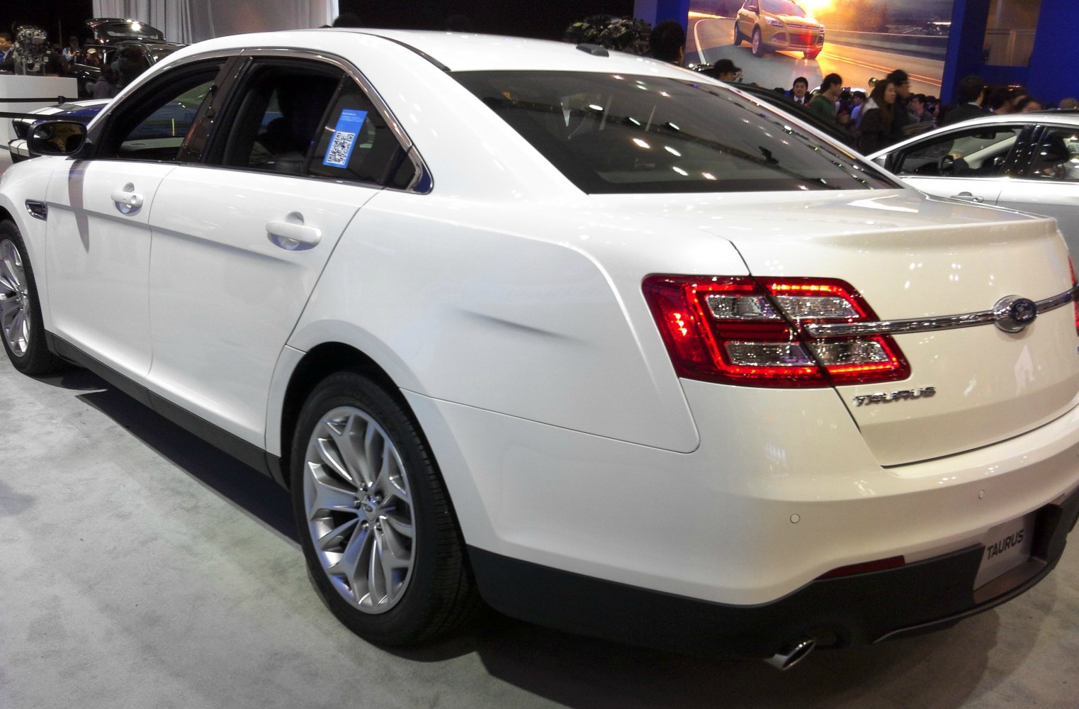 Rear and side view of white sedan with distinct taillights and alloy wheels