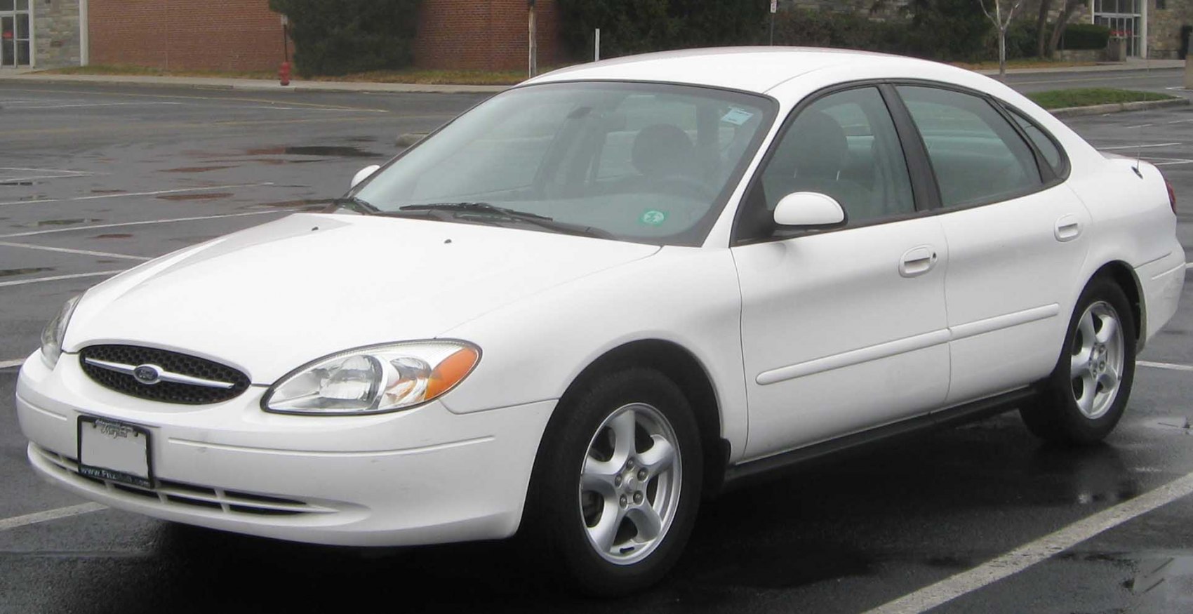 White sedan with rounded headlights and alloy wheels from front side view