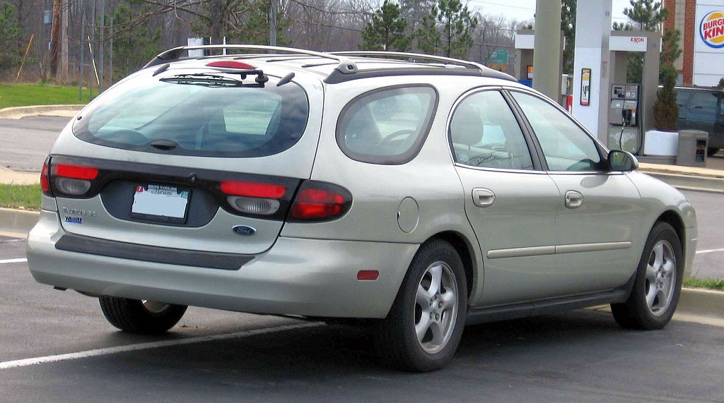 Rear and side view of silver station wagon with distinctive taillights