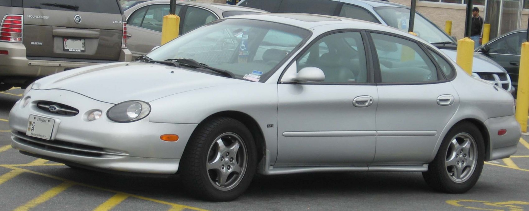 Silver sedan with rounded body and alloy wheels front side view