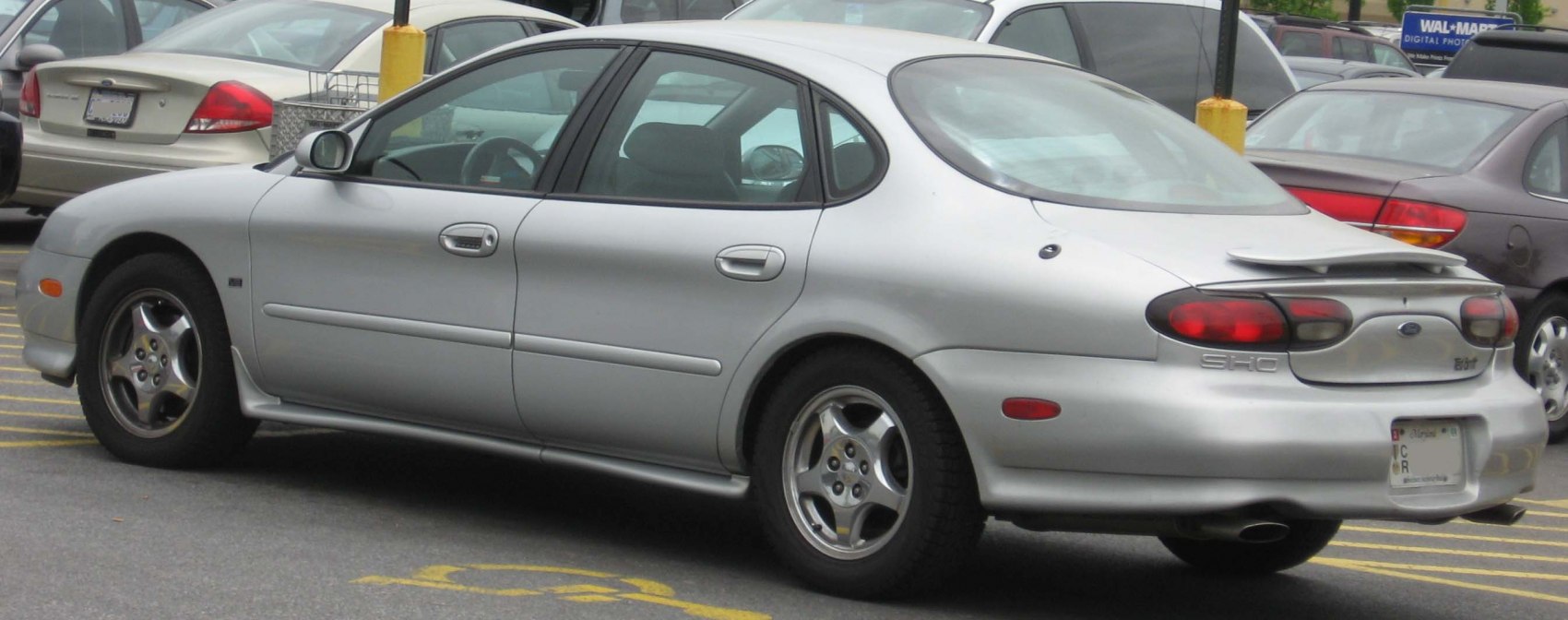 Silver sedan with rear spoiler and oval taillights from rear-side angle