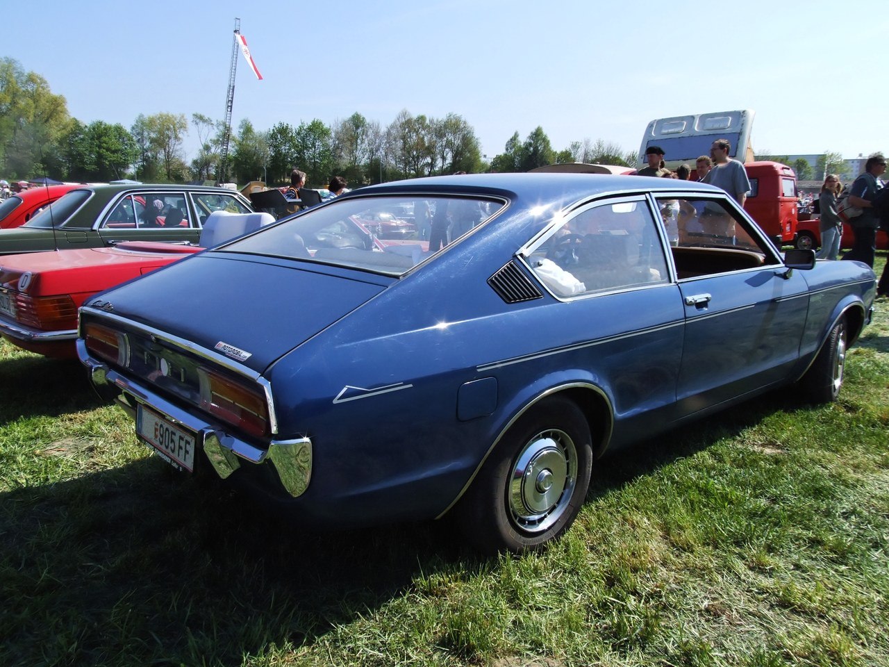 Blue vintage fastback coupe with chrome hubcaps and sculpted rear fenders