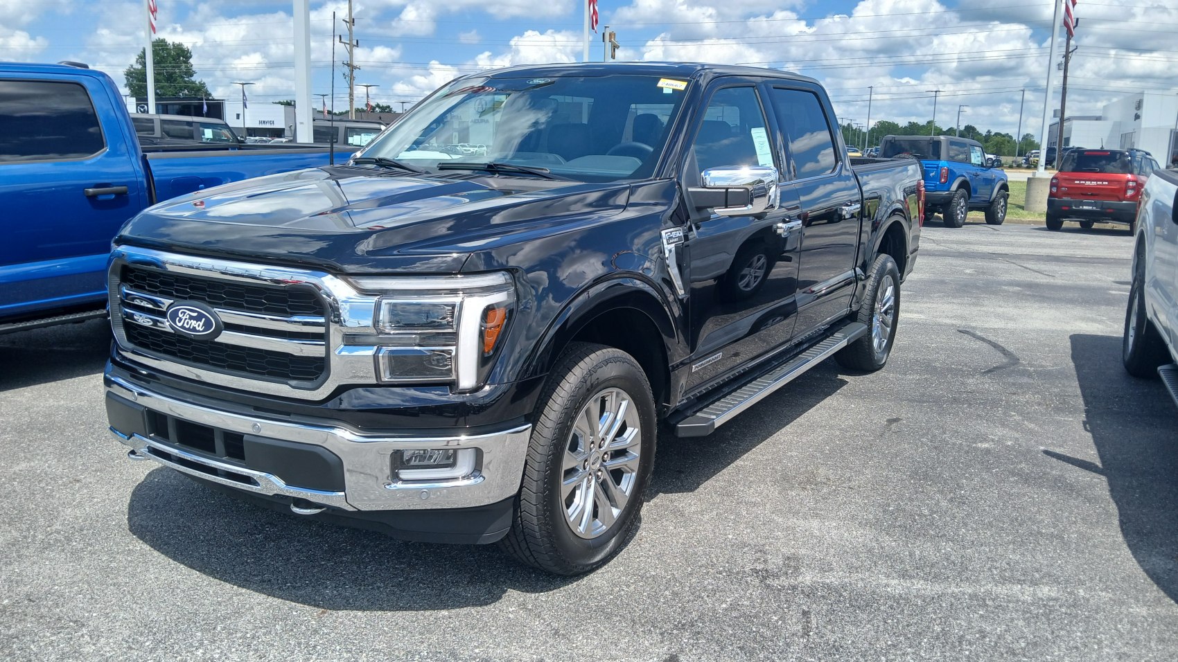 Front grille and side profile of a modern full-size pickup truck with chrome details and running boards.