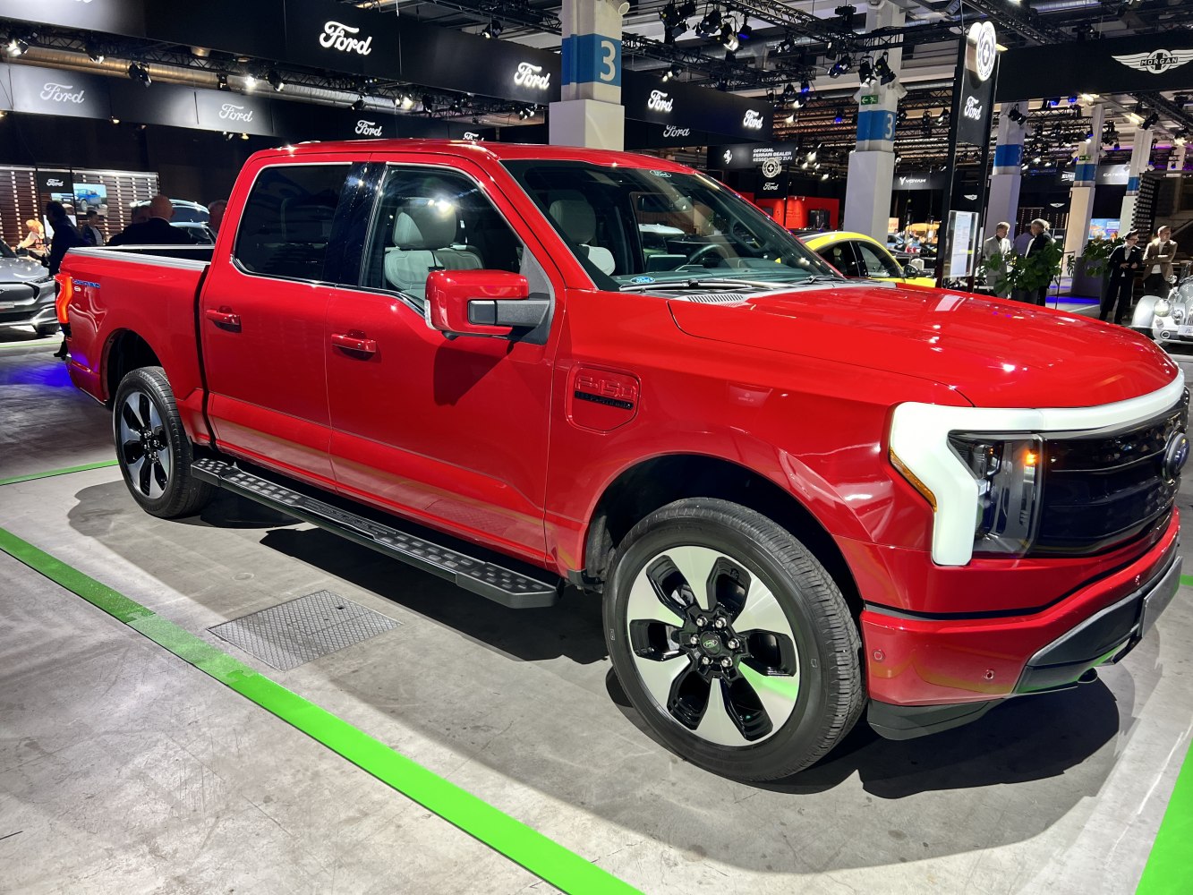 Red electric pickup with LED headlights and black alloy wheels