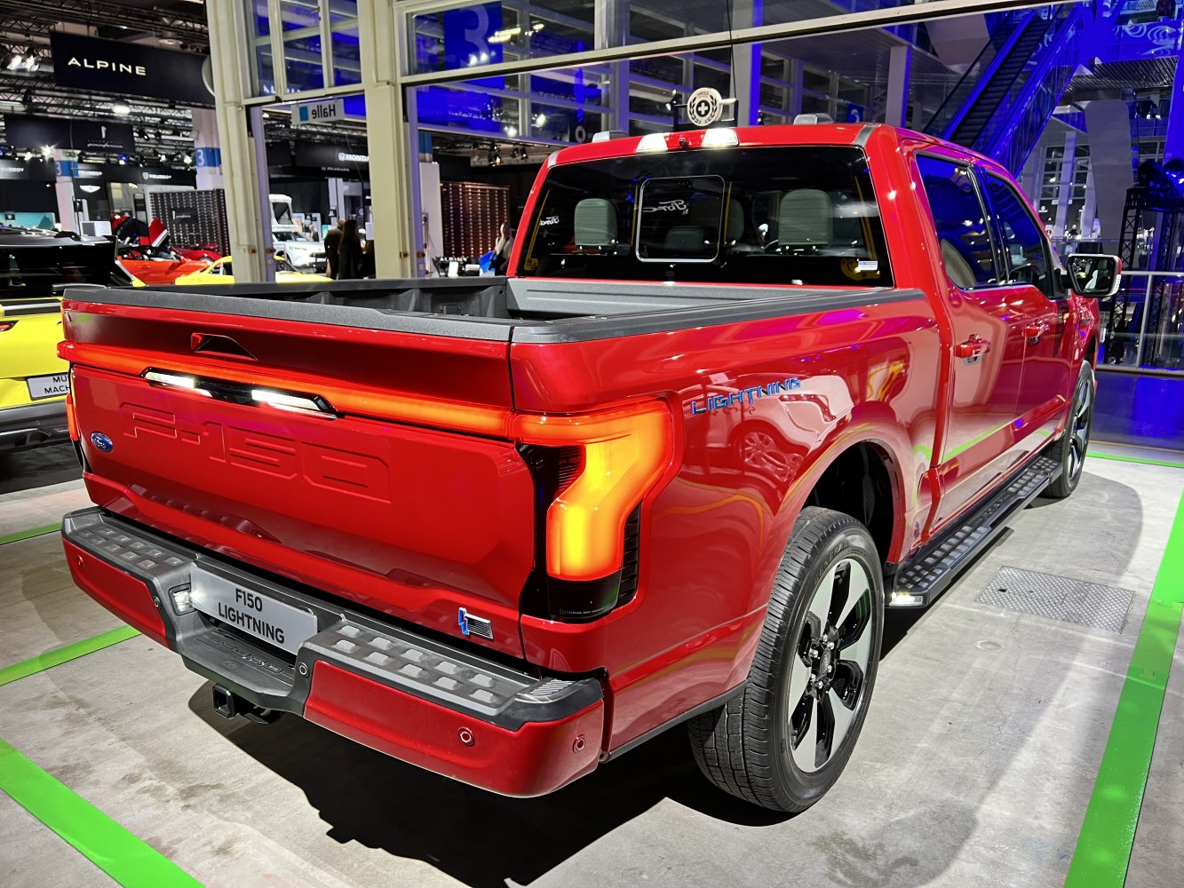 Red pickup truck rear and side view with LED taillights and SuperCrew cabin.