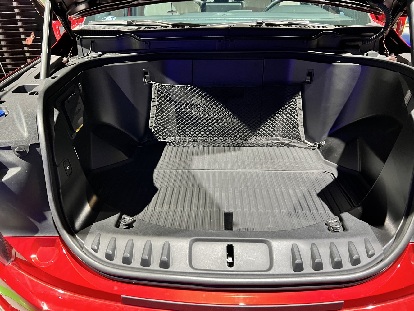 Electric truck front trunk with cargo net and molded storage space