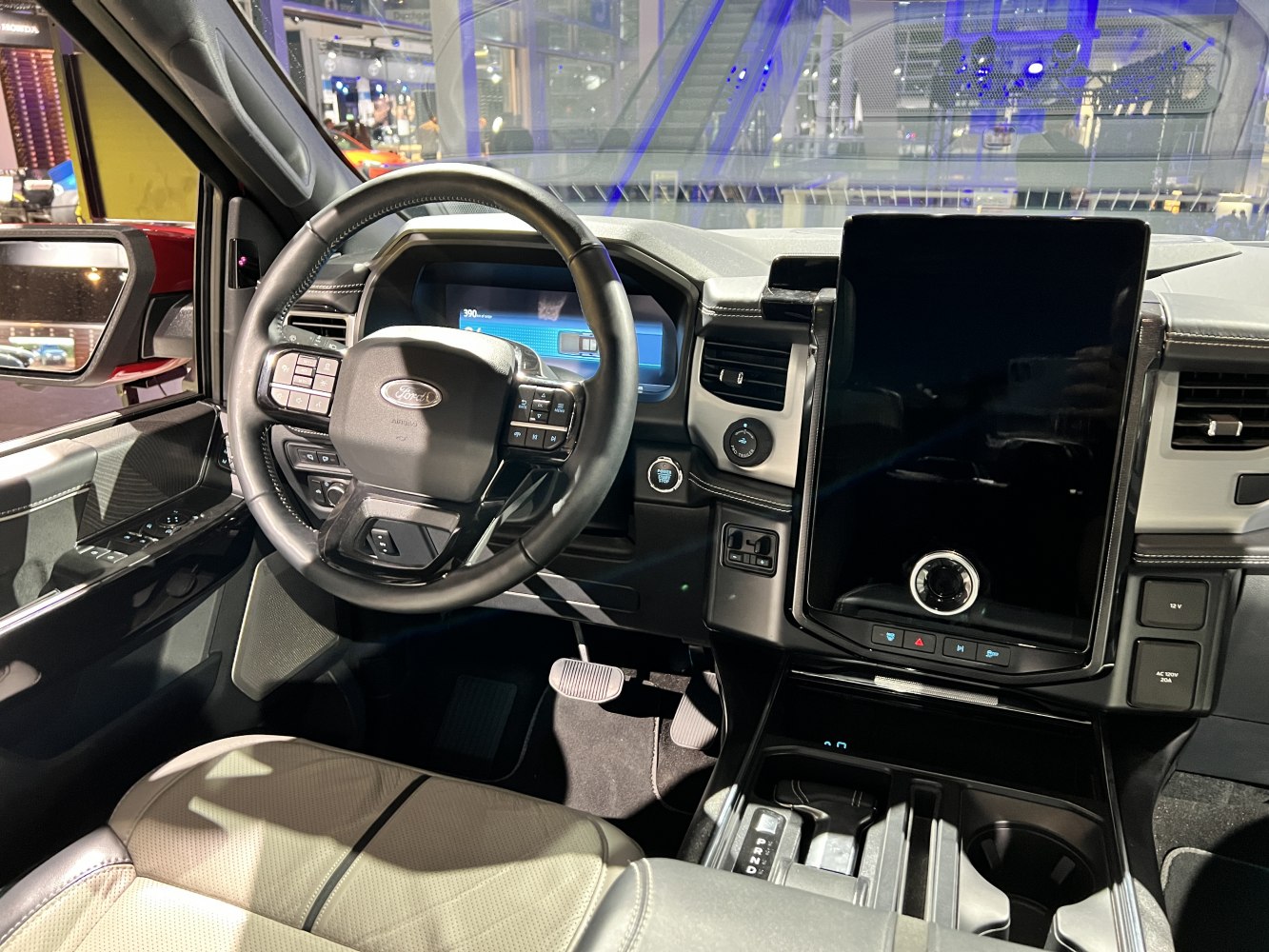 Digital instrument cluster and large vertical touchscreen display inside truck cabin.