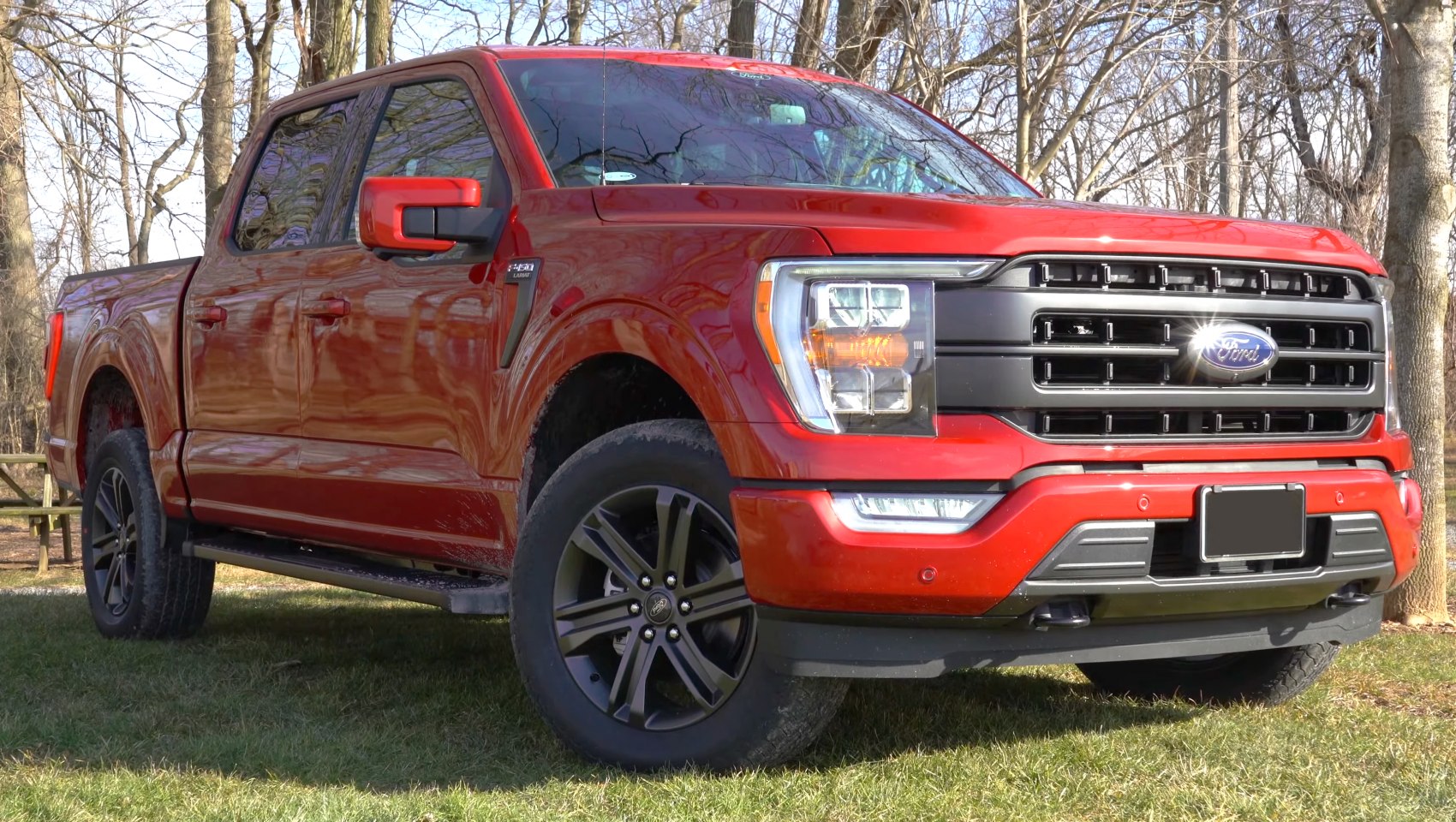 Red pickup truck front with black grille and alloy wheels