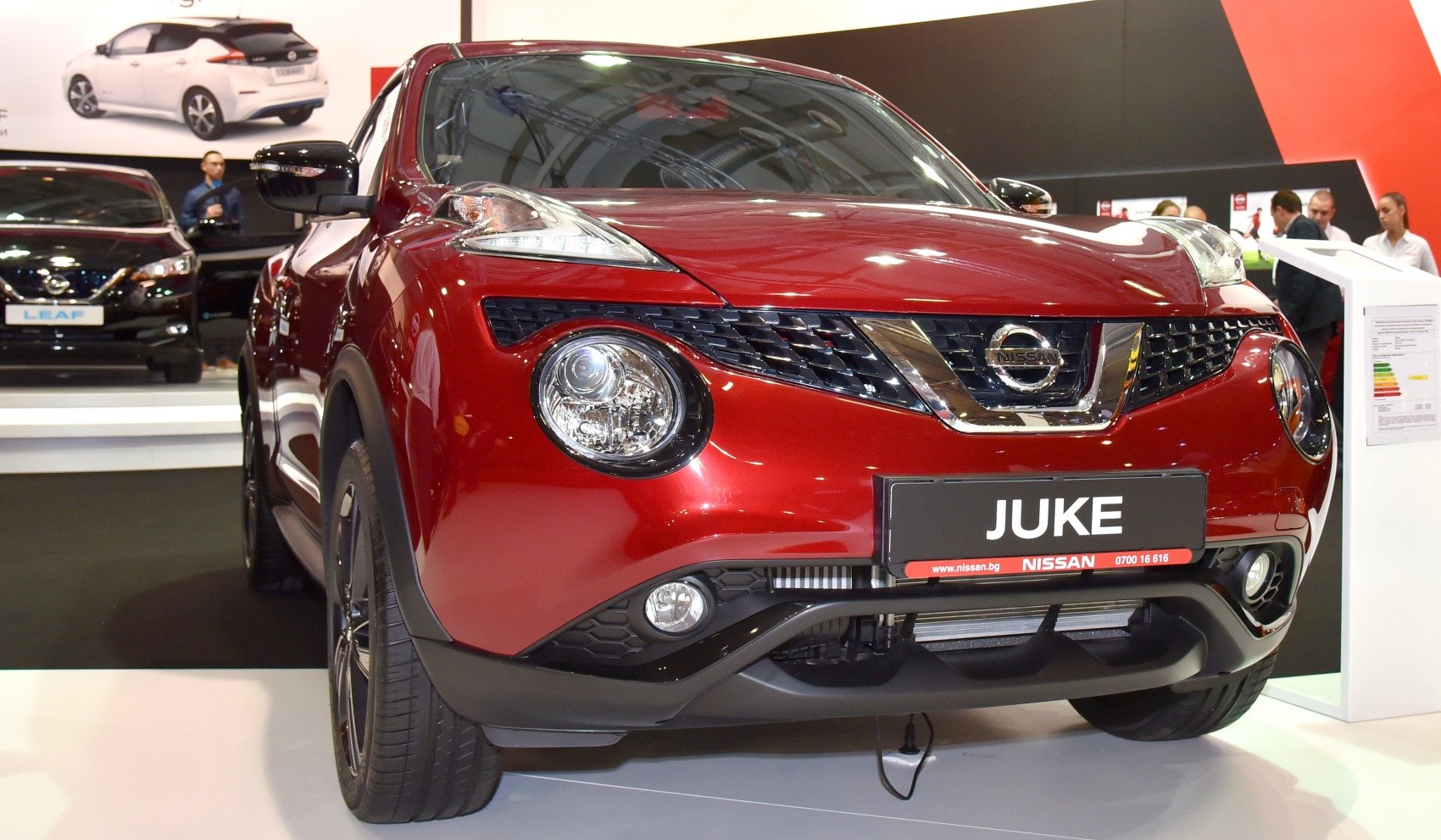 Front close-up of red compact crossover with split headlights and round fog lamps