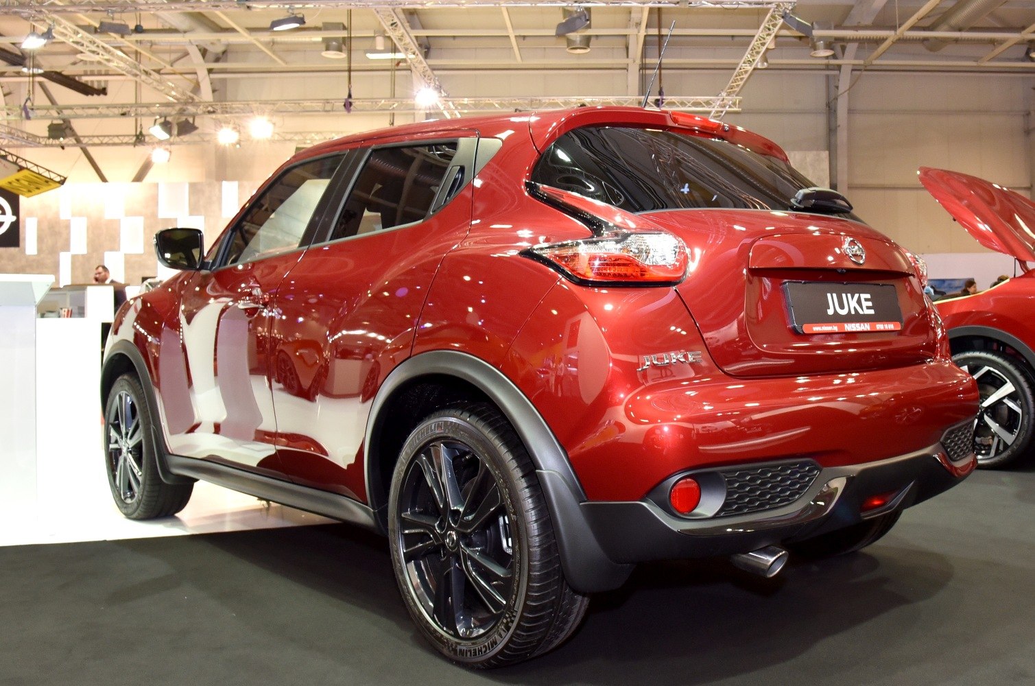 Glossy red compact crossover rear and side profile with black alloy wheels