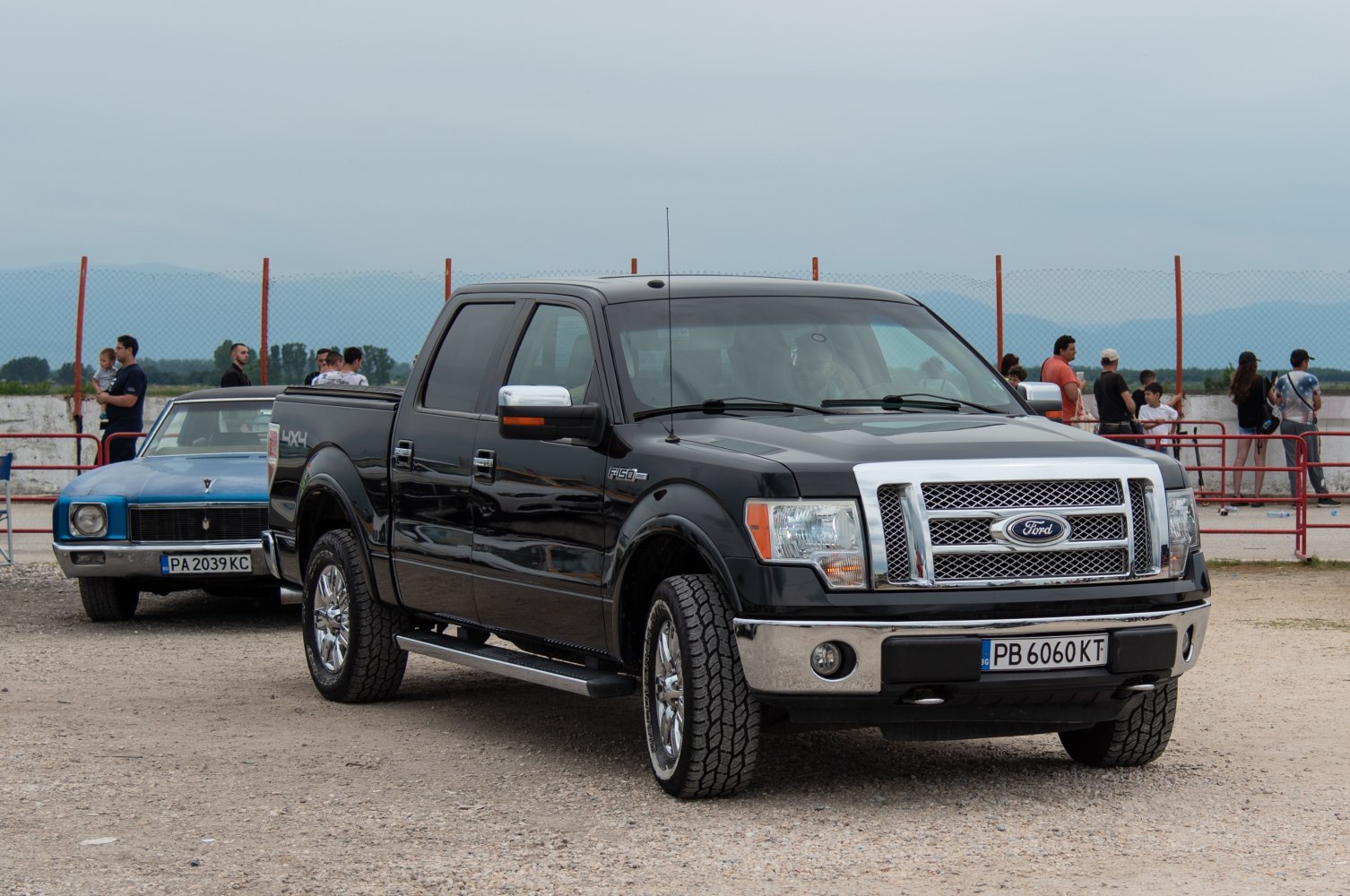 Black four-door pickup with chrome grille and off-road tires