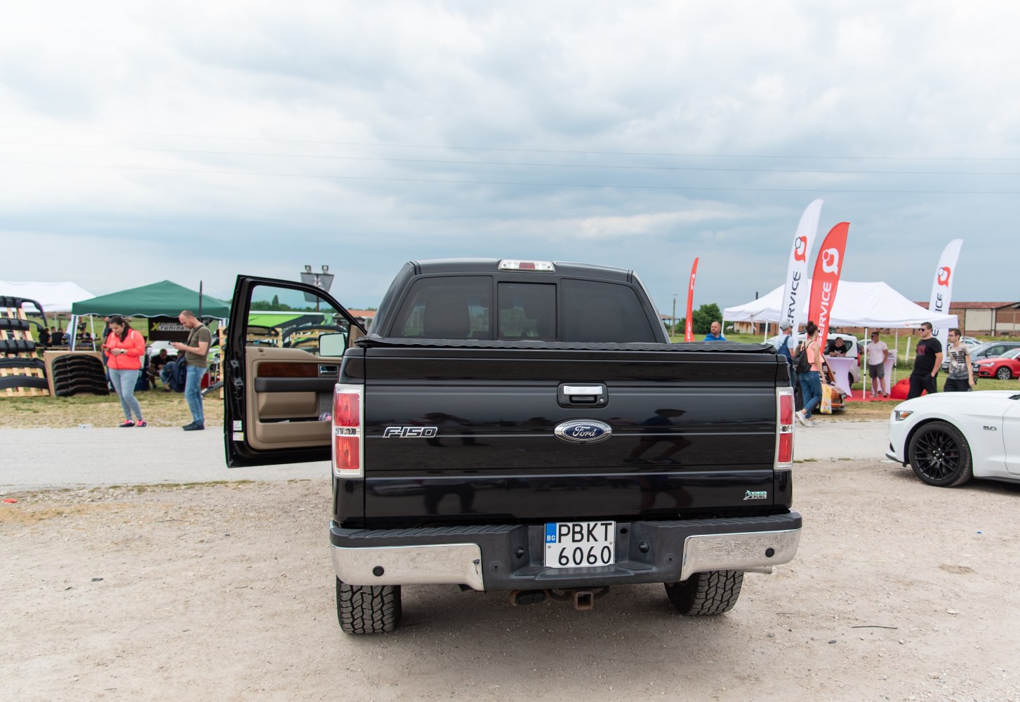 Rear view of pickup with open driver door and chrome bumper