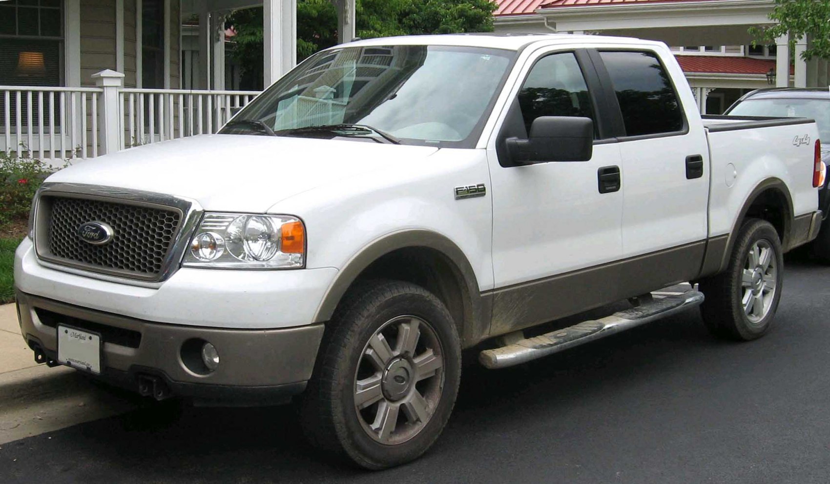 White pickup truck with extended cab and alloy wheels front-side view