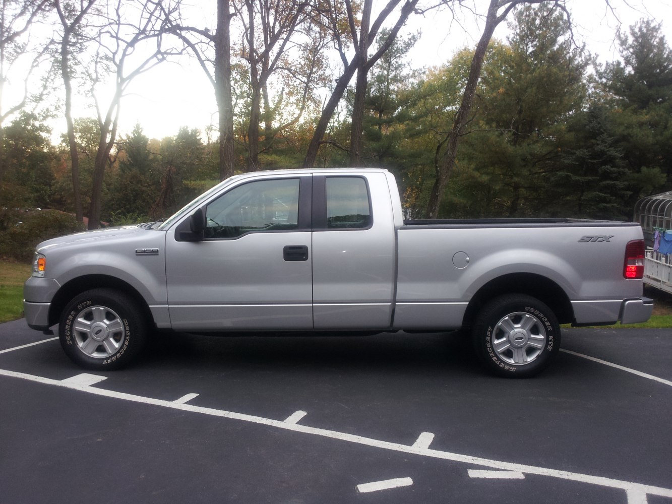 Silver extended cab pickup truck with long bed side profile