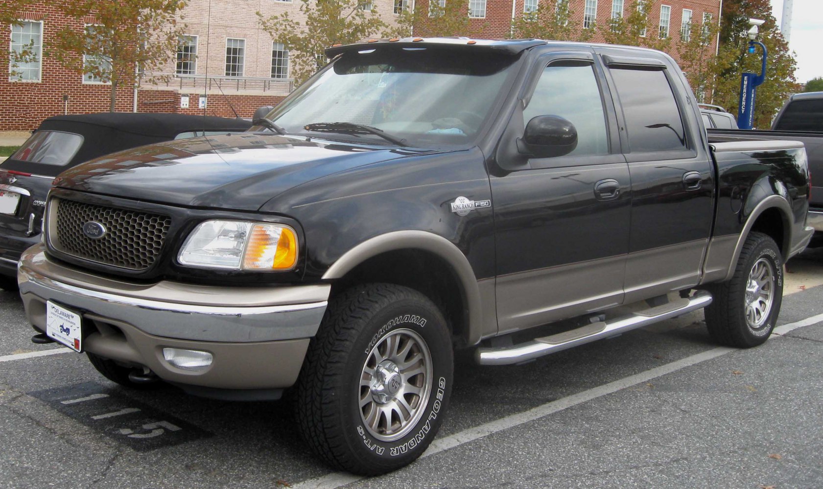 Black and beige two-tone pickup truck with extended crew cab and off-road tires