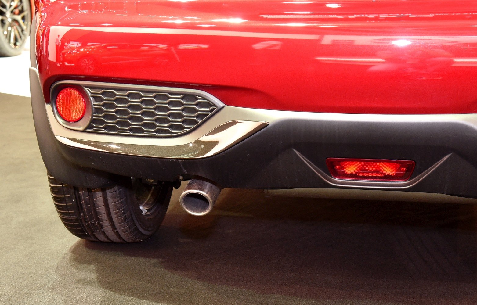 Rear bumper with exhaust pipe and tail light reflector