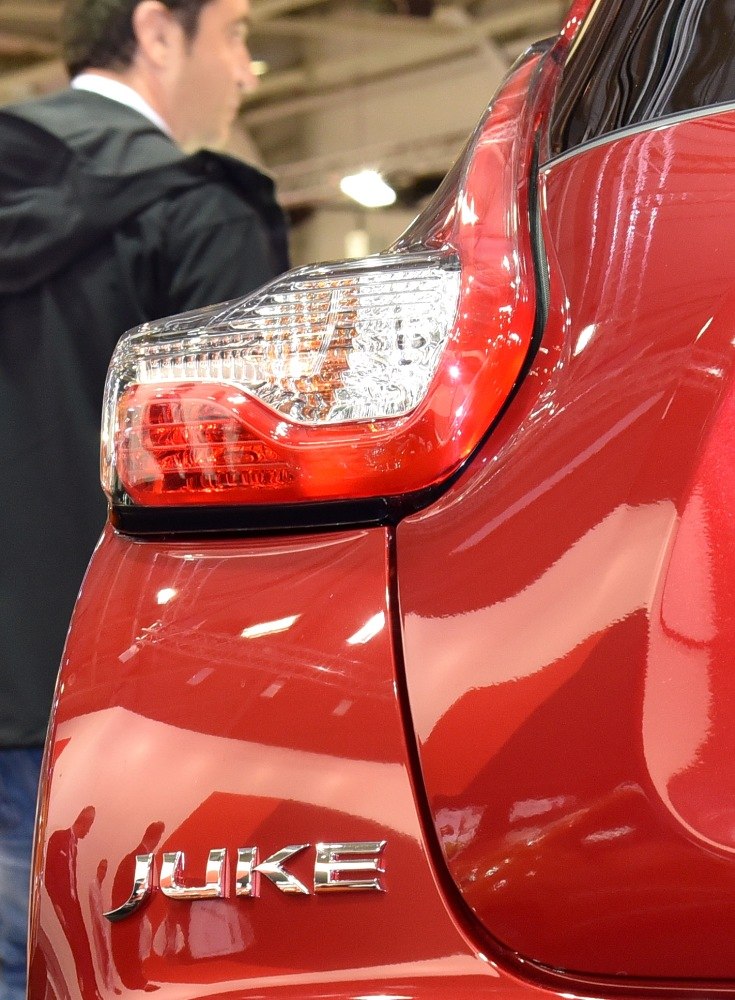 Close-up of rear taillight and Juke badge on red car