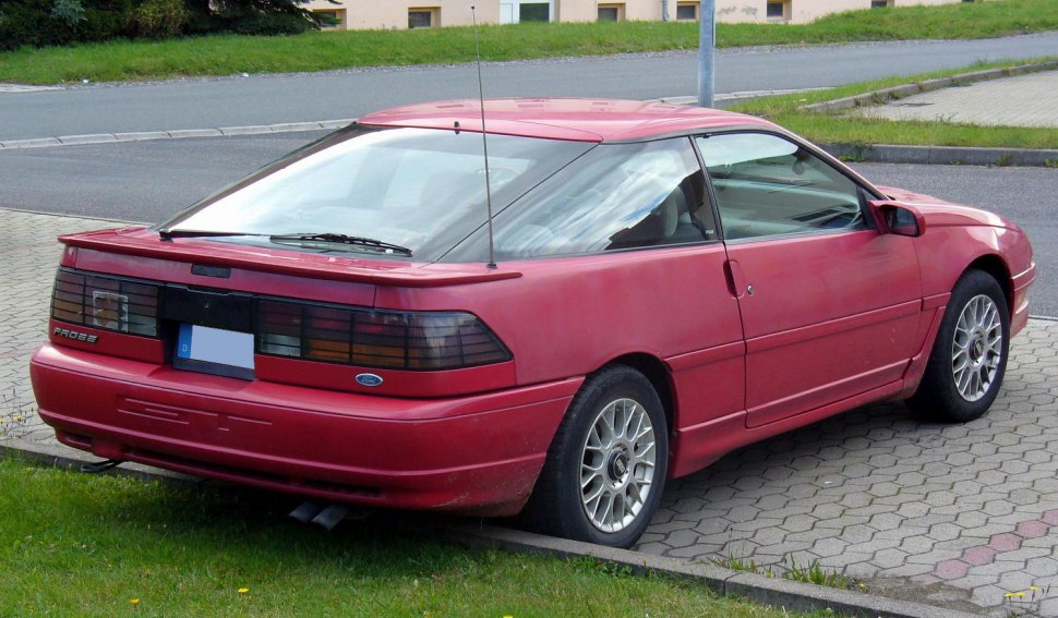 Rear view of a red sporty coupe with dark tail lights and spoiler