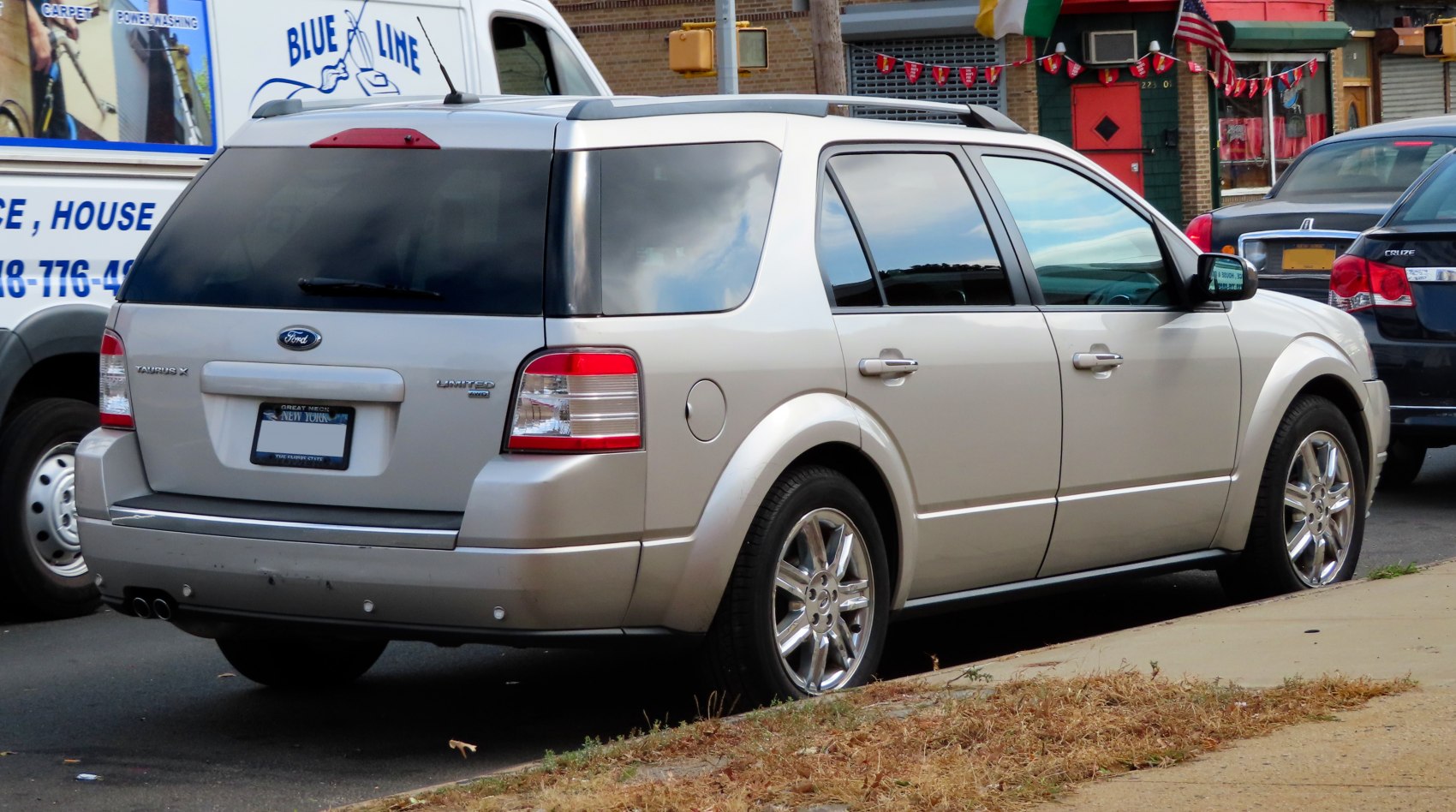 Silver SUV rear side with chrome wheels, tinted windows, and roof rails
