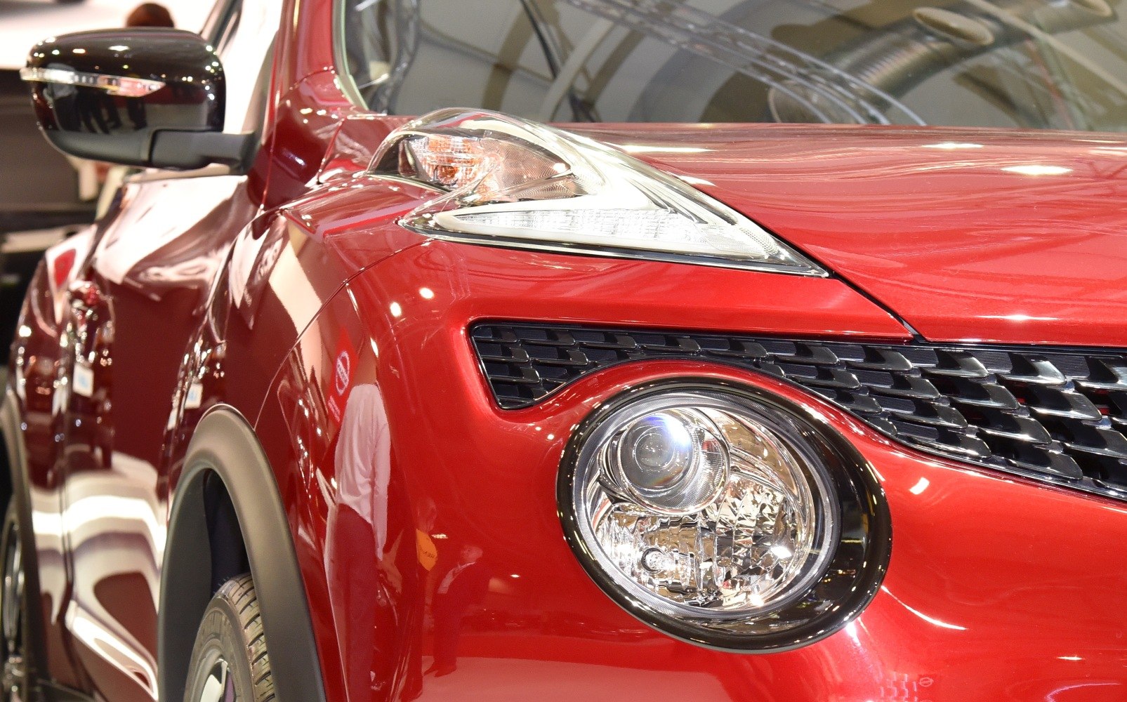 Close-up of front headlight and grille with red front fender.