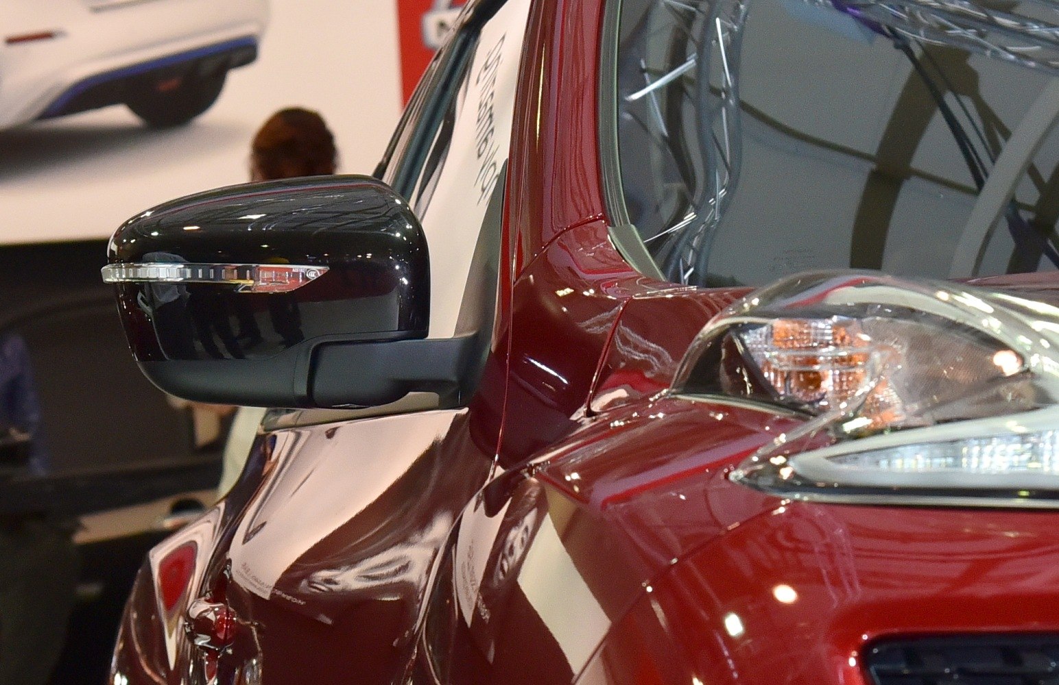 Close-up of side mirror with turn signal and front headlight
