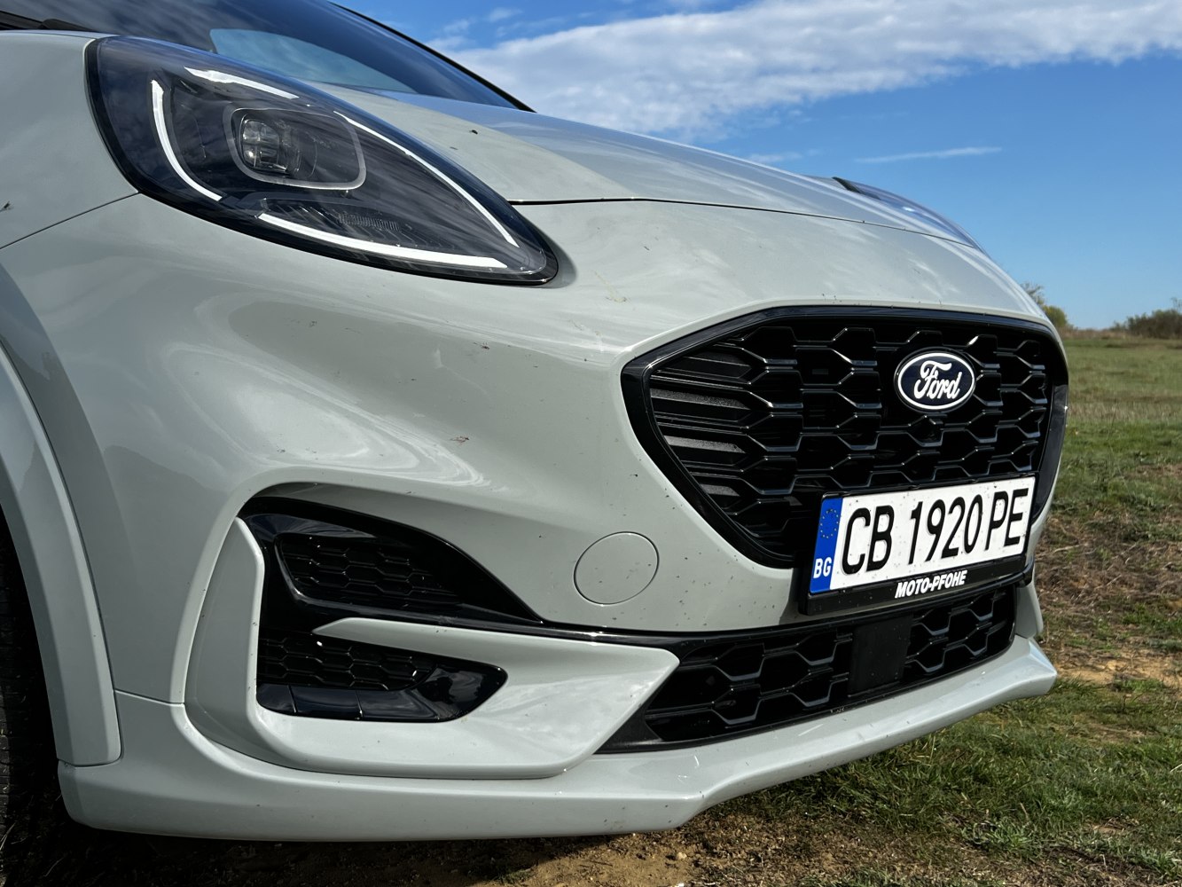Close-up of sleek headlight and honeycomb front grille design.