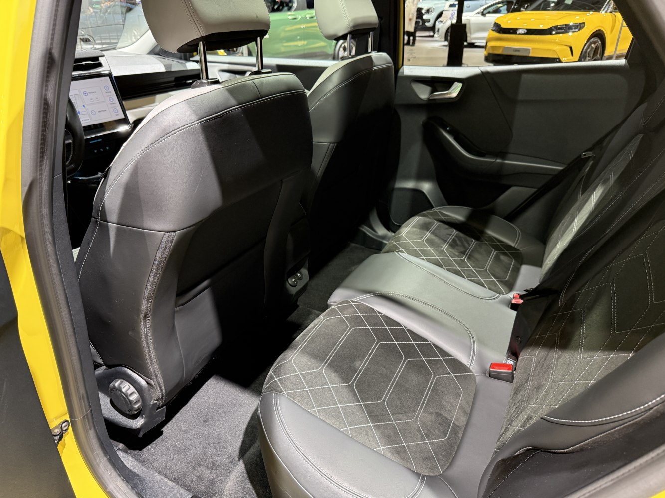 Rear seat upholstery with geometric pattern and black trim in modern car interior