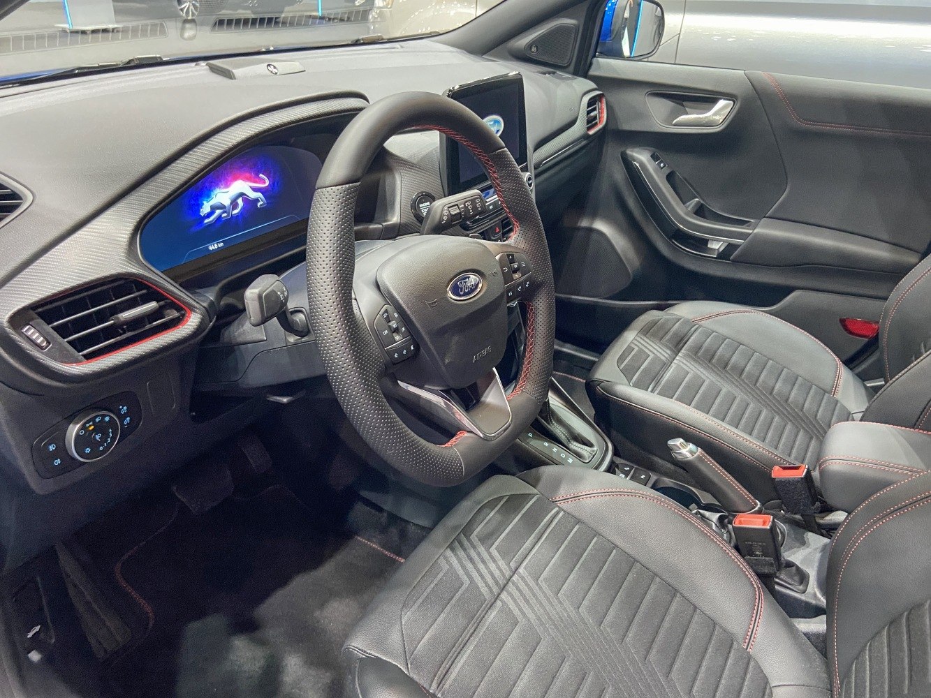 Modern dashboard and steering wheel with digital display and red stitching
