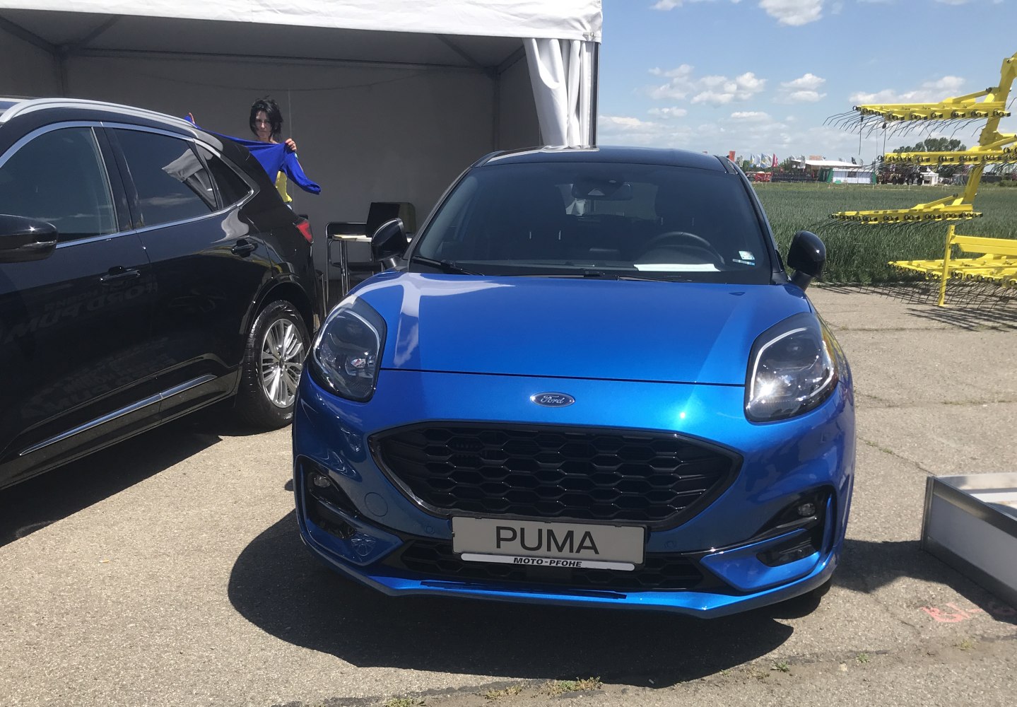 Close-up of blue vehicle front with hexagonal grille and modern headlights