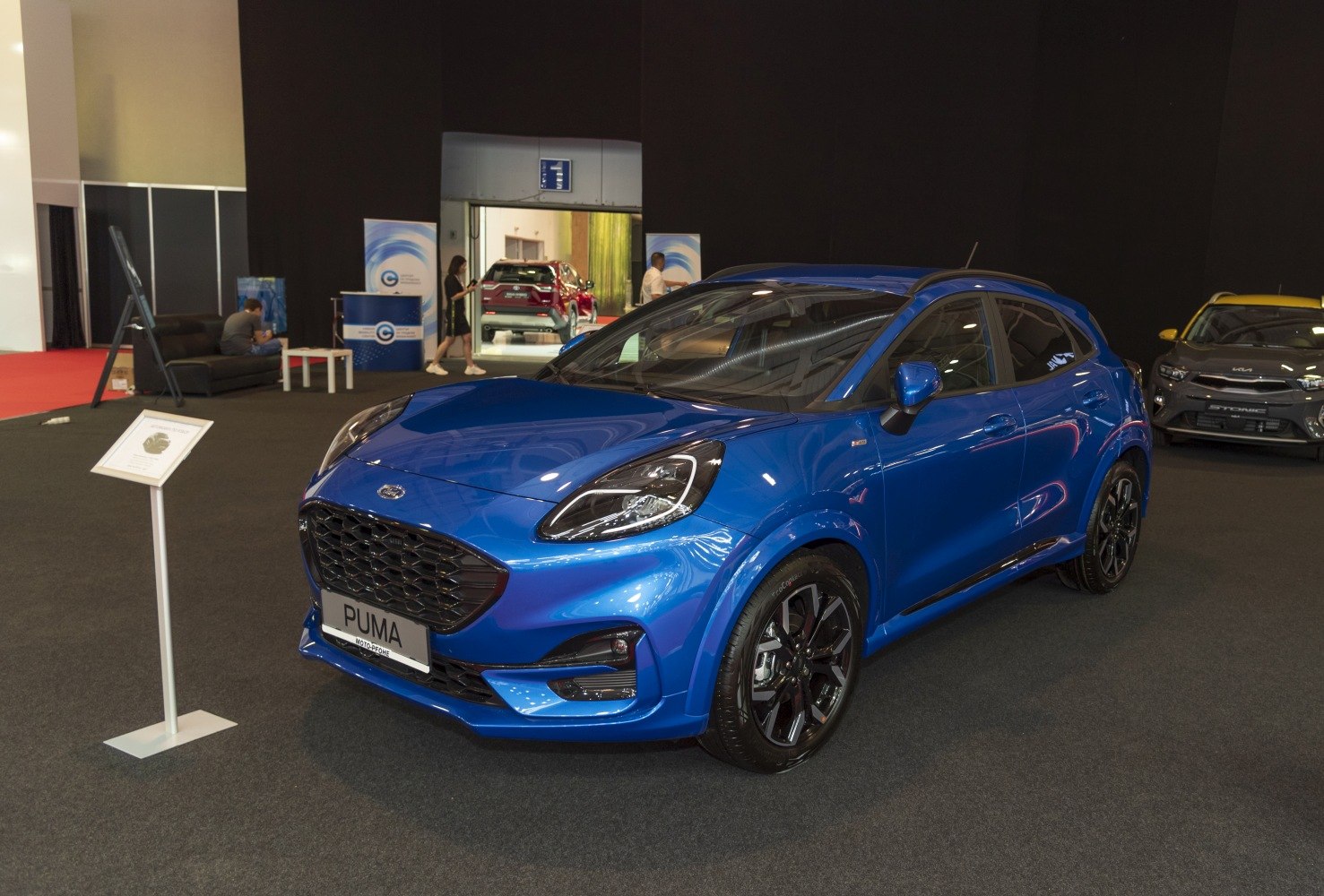 Blue compact hatchback with sleek front grille and alloy wheels