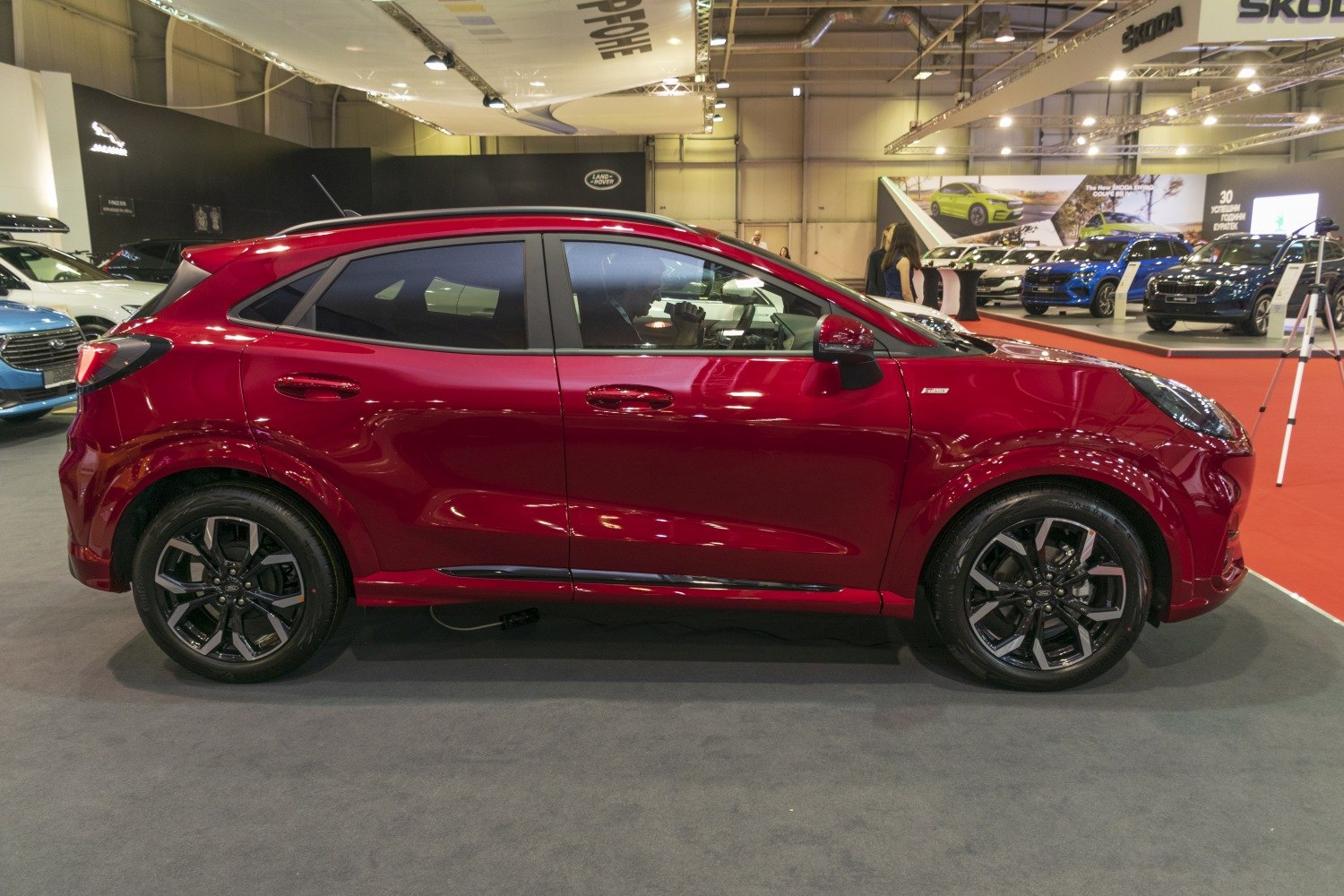 Side profile of sporty red hatchback with black alloy wheels