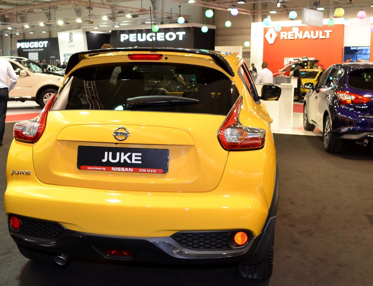 Yellow hatchback rear view with unique taillight design and roof spoiler