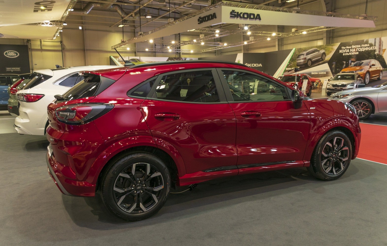 Side view of a red compact SUV with black alloy wheels