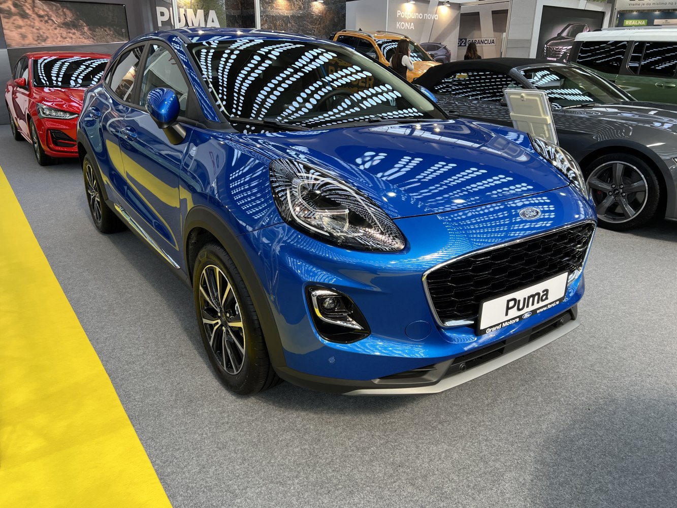Front and side view of blue Ford Puma with headlights and grille visible