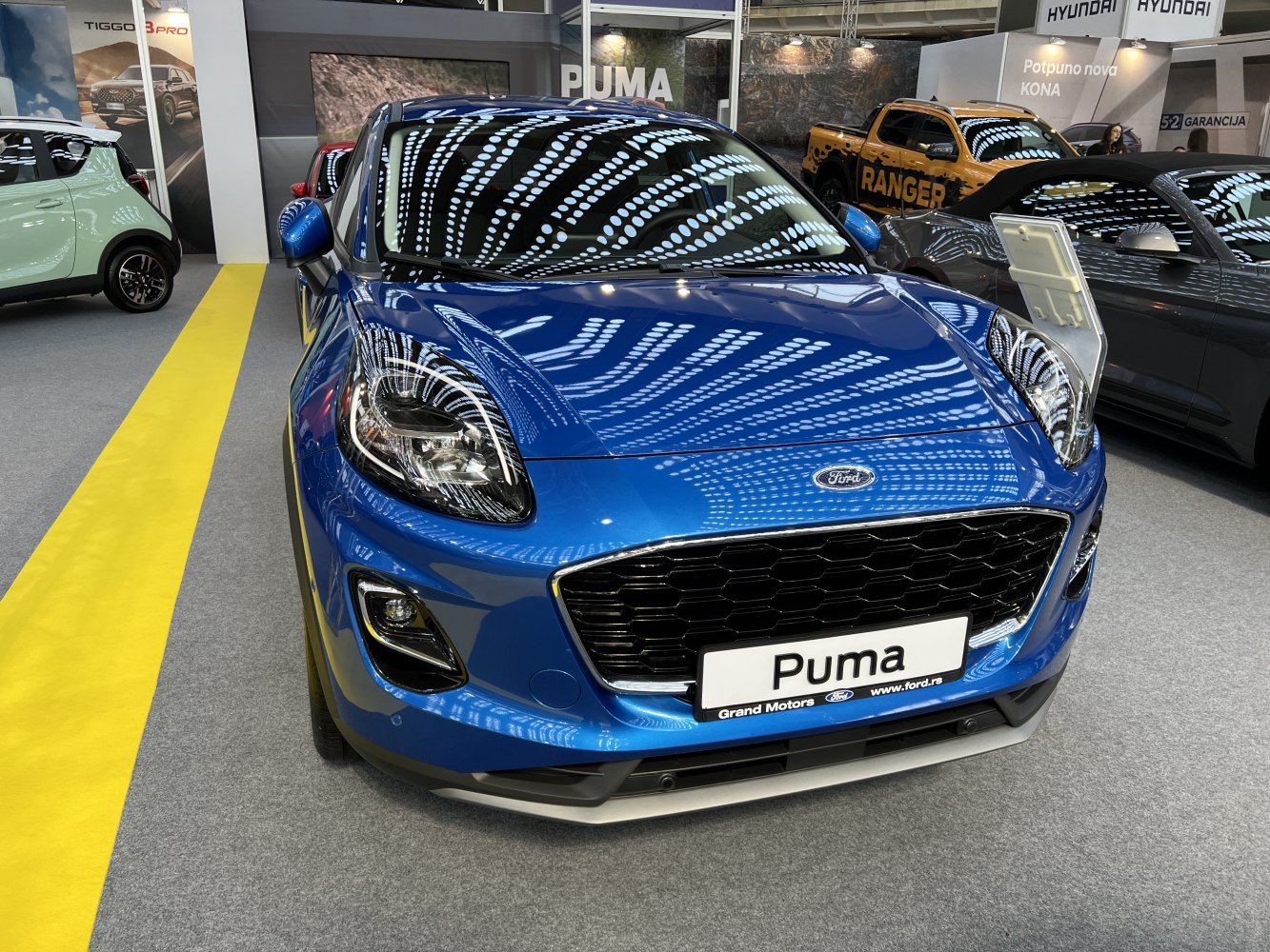 Blue car front with large grille and modern headlights