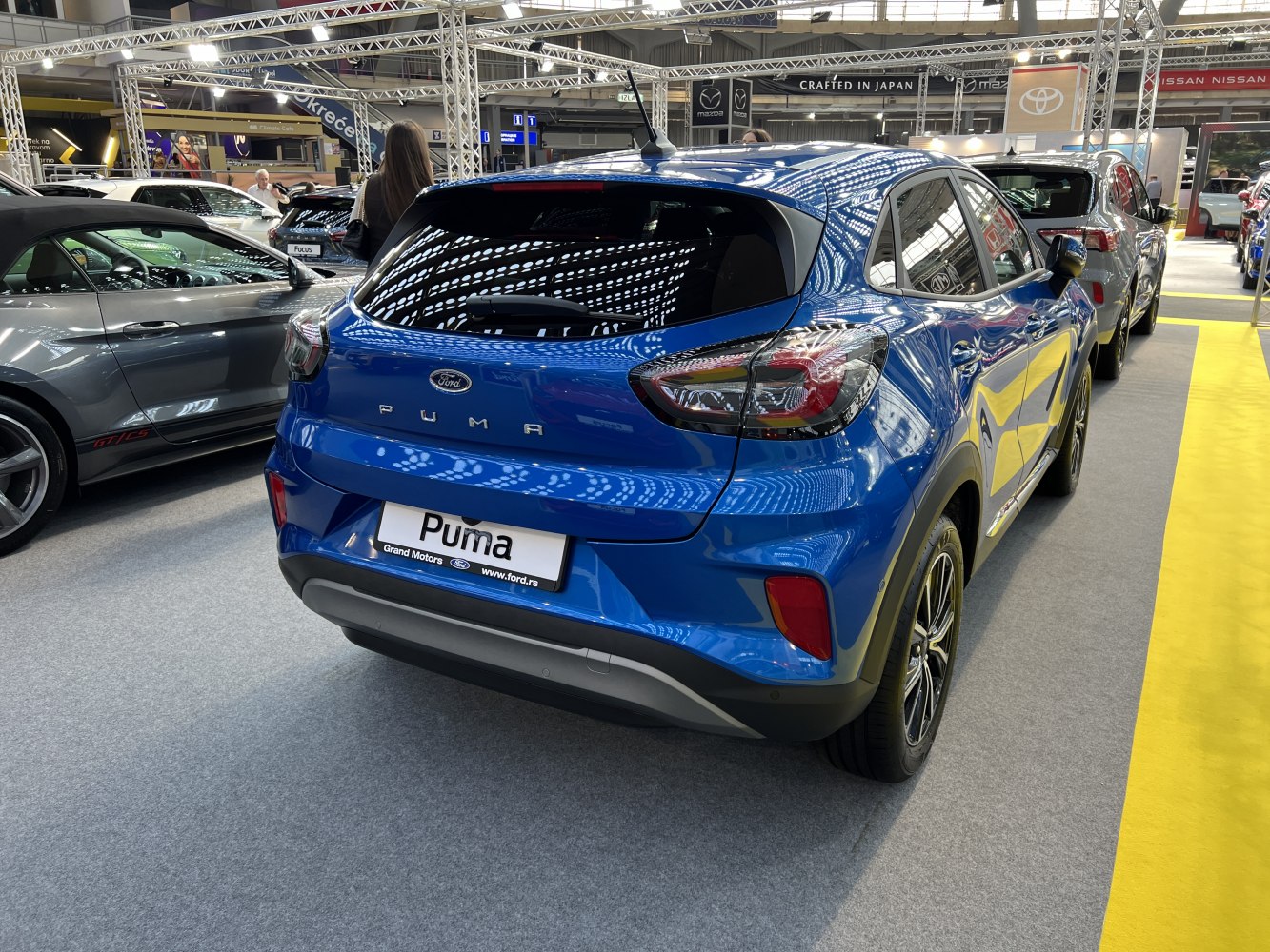 Rear view of a blue compact SUV with distinctive tail lights and sporty design.