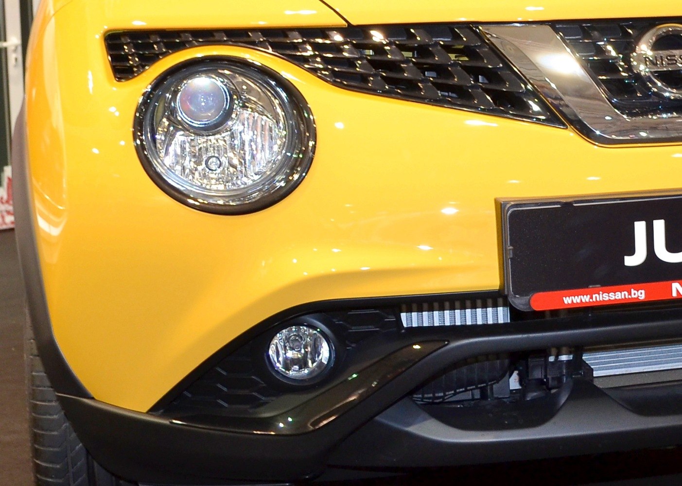 Round front headlight and fog light with black grille and yellow bumper